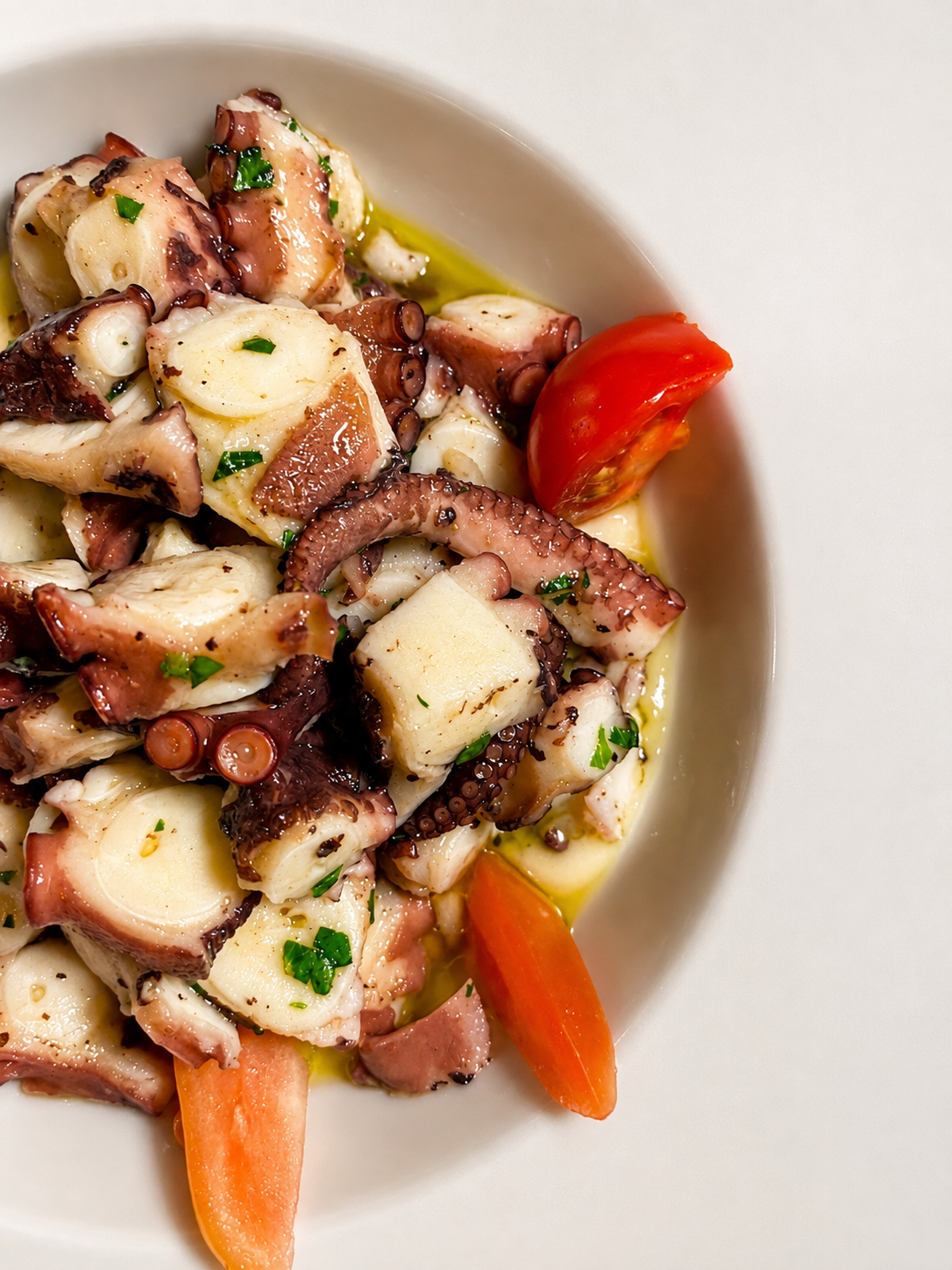 Polpo condito con olio, prezzemolo e pomodorini
