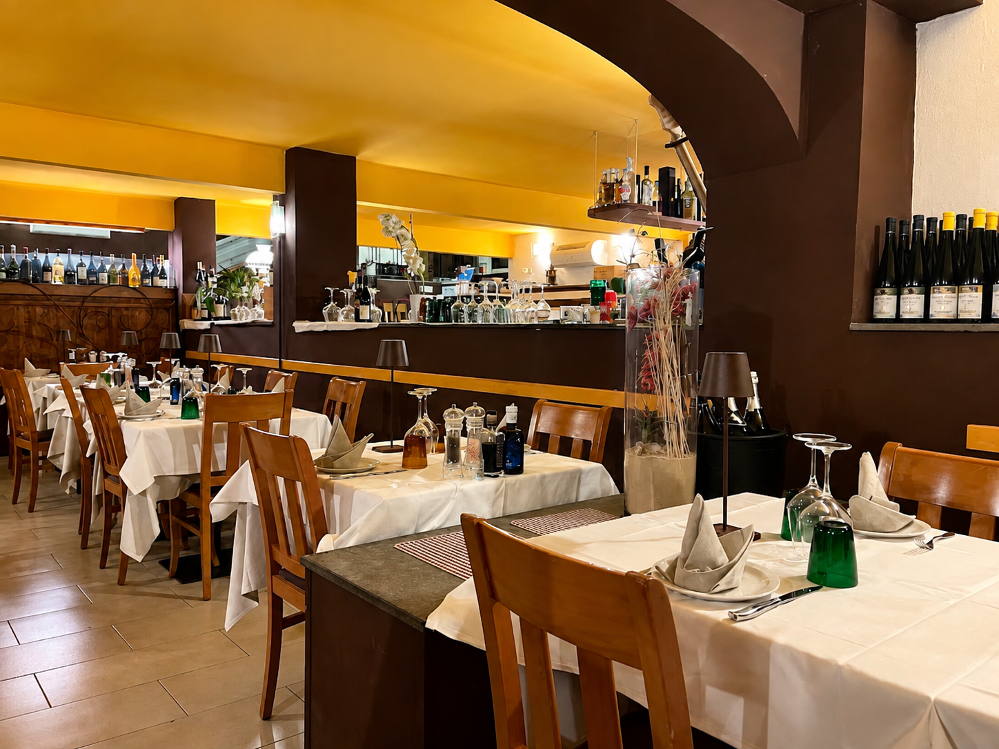 Sala interna de La Taverna con tavoli apparecchiati e luci calde