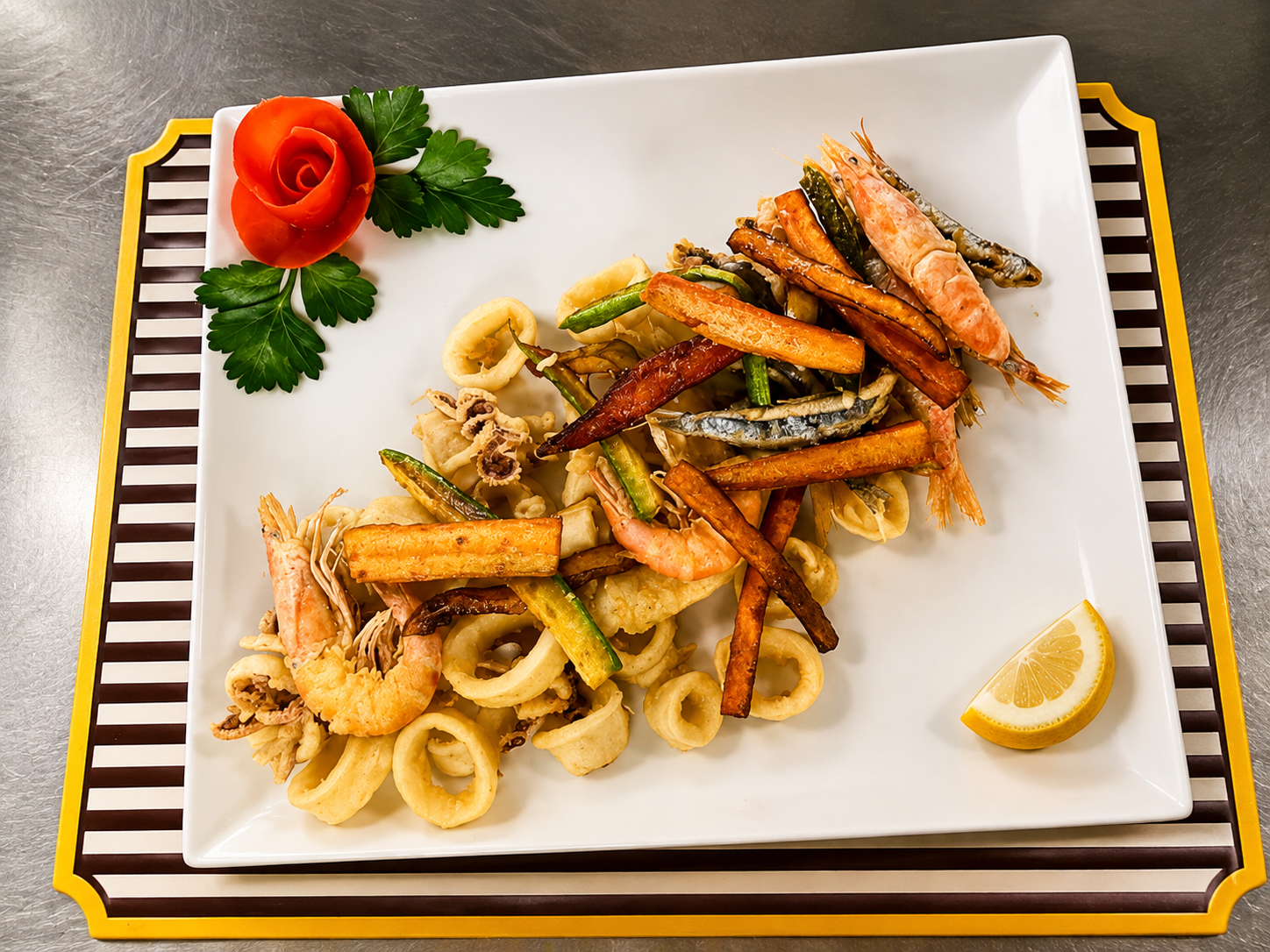 Frittura di mare con calamari, gamberi, verdure, limone e rosa di pomodoro